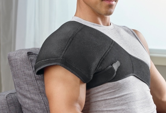 A man sitting, wearing a black shoulder brace.