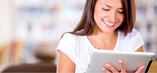 A woman looking at a tablet.
