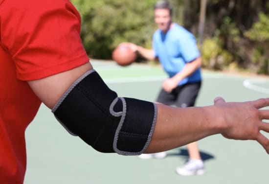 Un joueur de basketball portant une attelle pour coude.