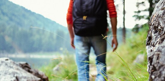 Man backpacking near a lake.

